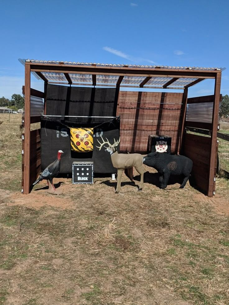 an outhouse with fake animals in it and other things on the ground around it