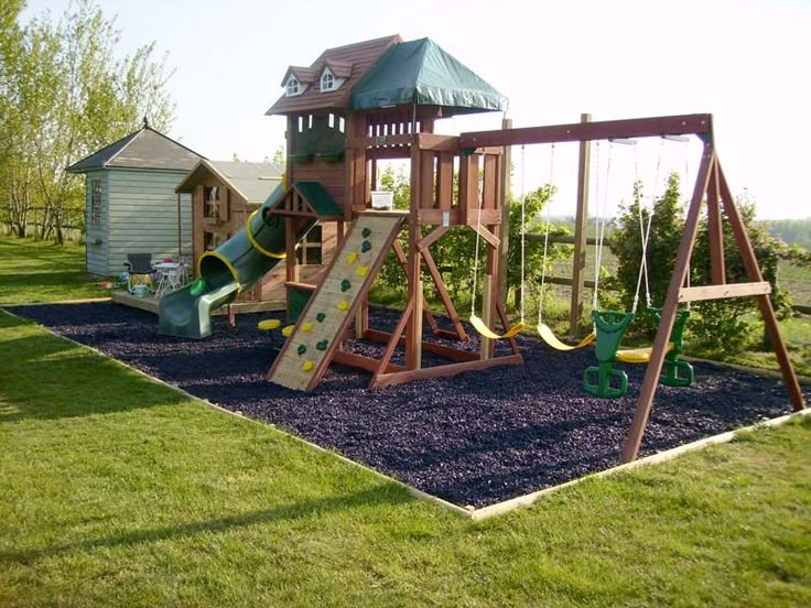 a wooden swing set in the middle of a yard