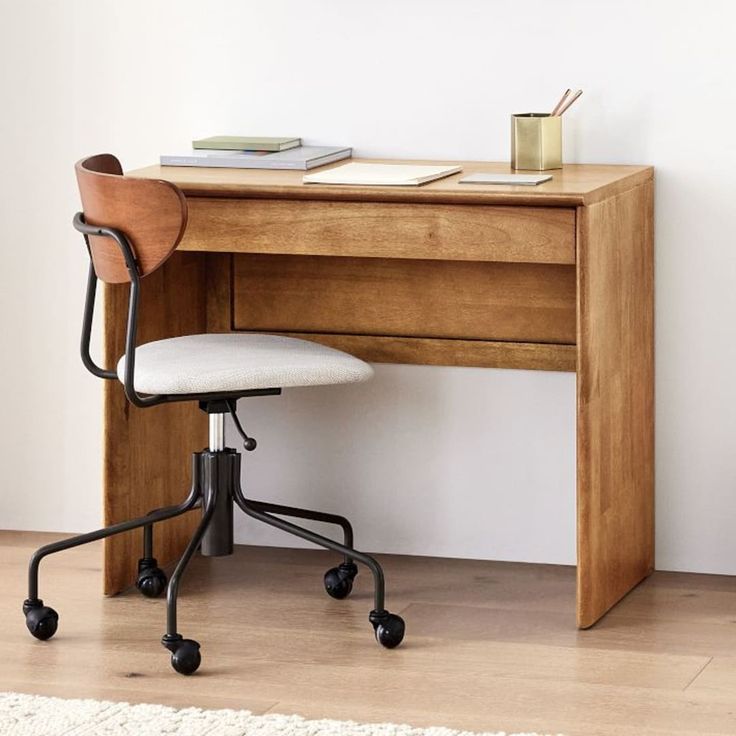 a desk with a chair and a book on it in front of a white wall