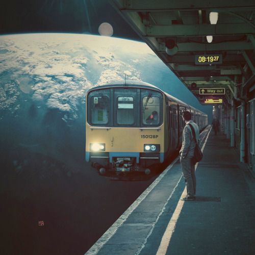 a man standing next to a train at a station with the earth in the background