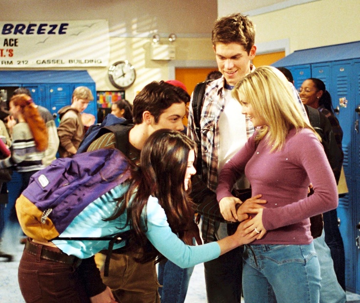 group of people standing around each other near lockers