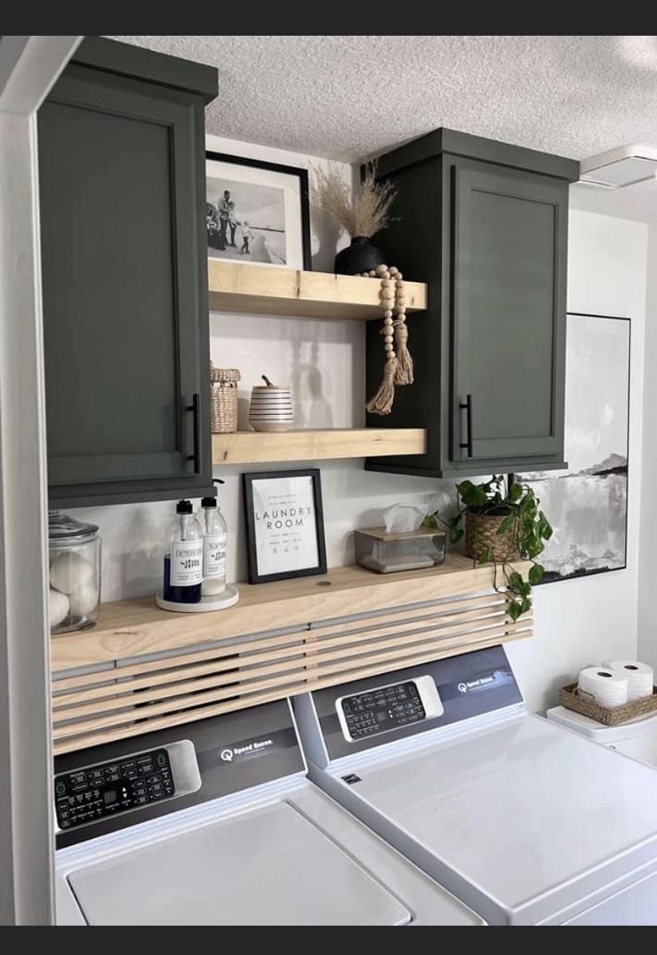 a washer and dryer in a laundry room with cabinets above the washer