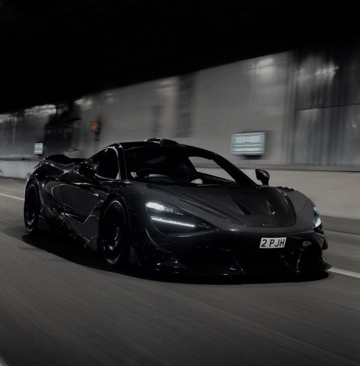 a black sports car driving down the road