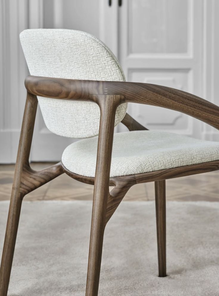 a white chair sitting on top of a carpeted floor next to a wooden frame