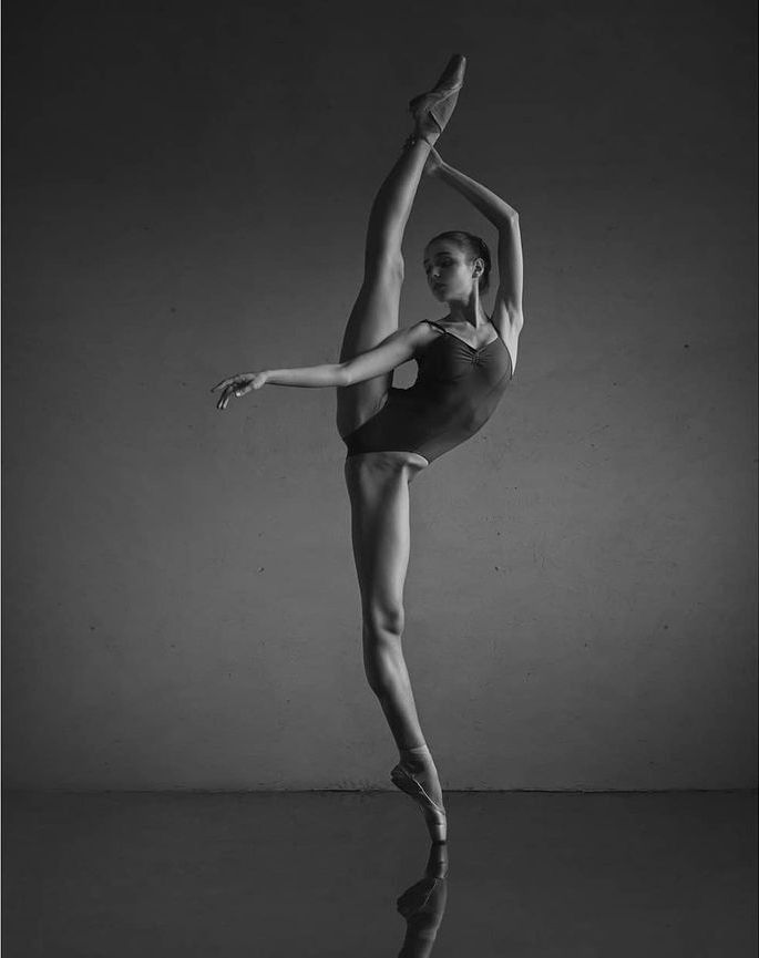 a woman in a leotard is standing on one leg