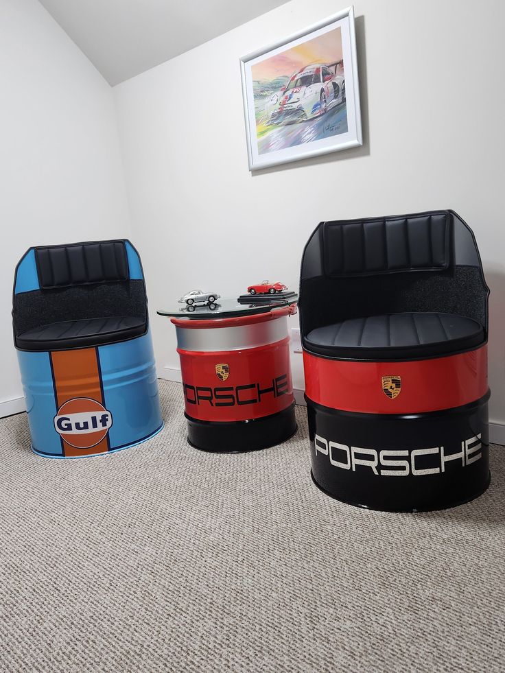 three colorful storage containers sitting on top of carpeted floor next to a wall with pictures above them