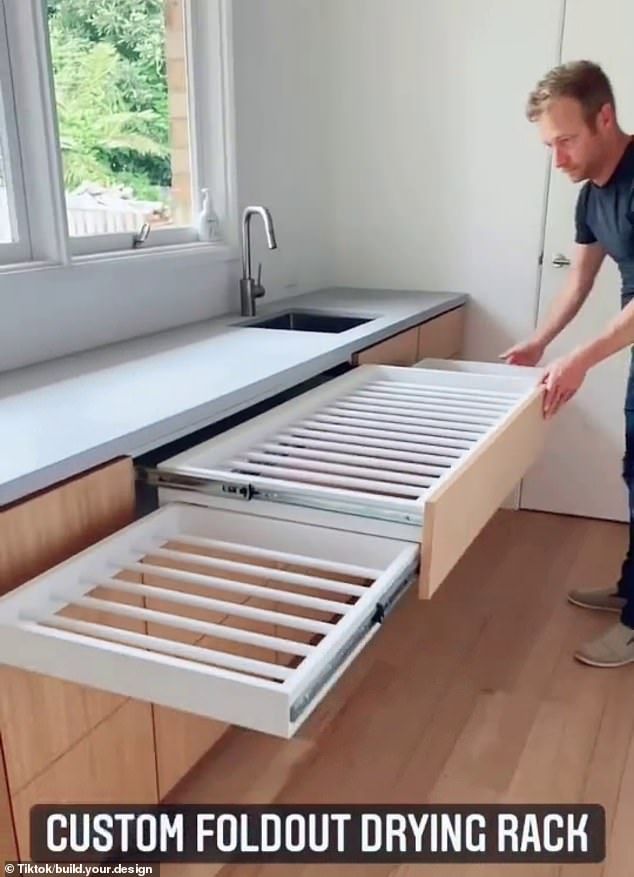 a man standing next to an open drawer in a kitchen with the words custom foldout drying rack