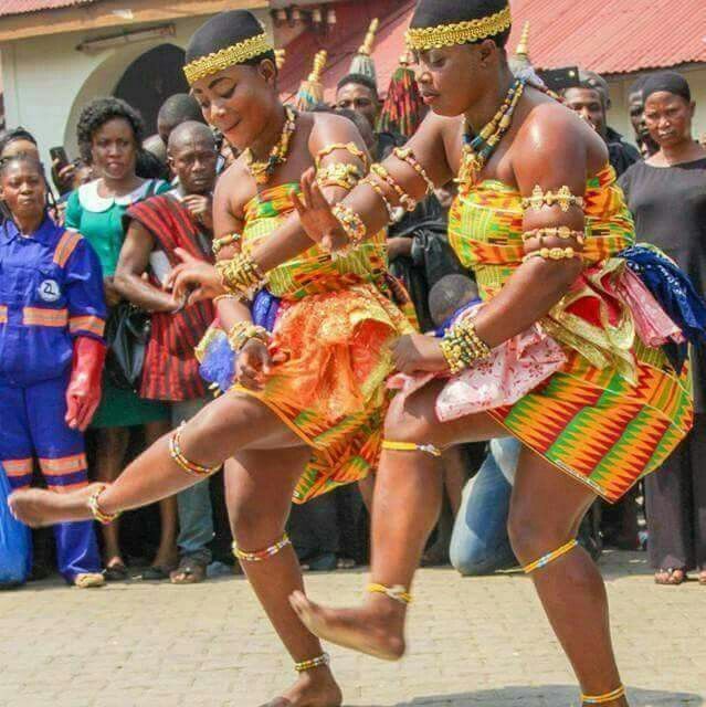 two women in colorful costumes dancing on the street