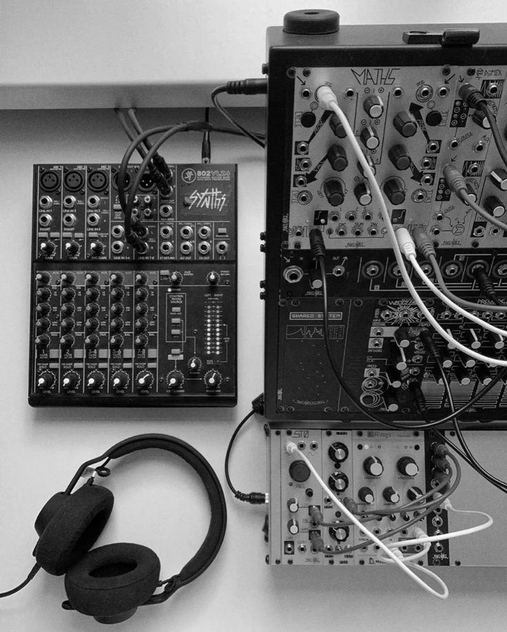 an assortment of electronic equipment sitting on top of a table next to headphones and wires