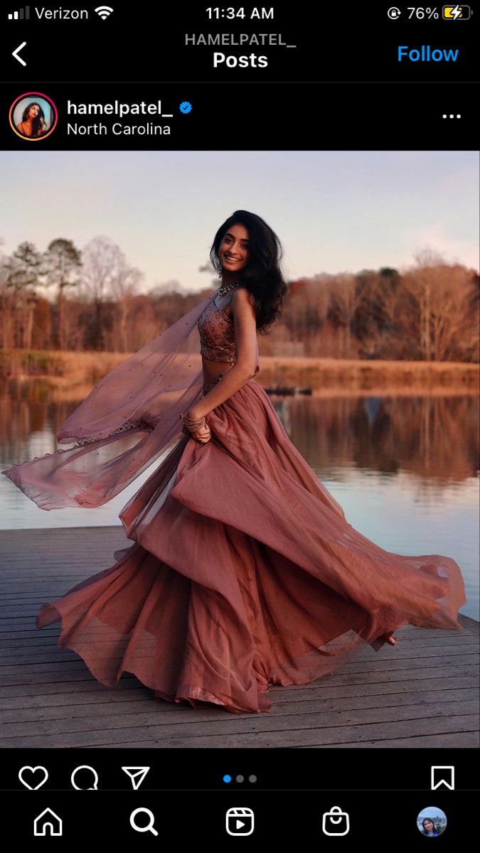 a woman in a long dress standing on a dock