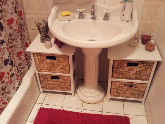 a white sink sitting under a bathroom mirror