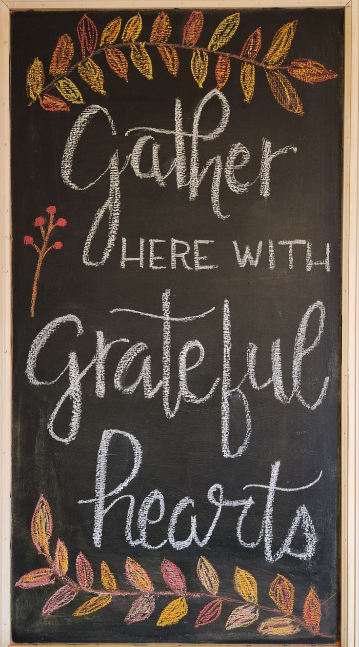 a chalkboard sign that says gather here with grateful hearts