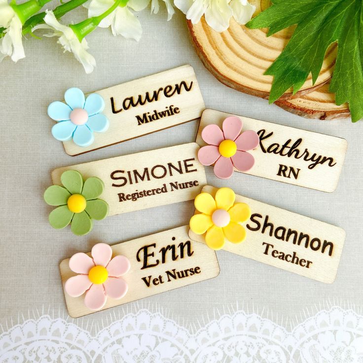 four wooden name tags with flowers on them