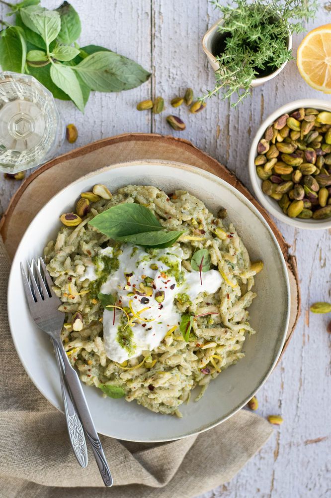 a white bowl filled with rice and topped with sour cream on top of a wooden table