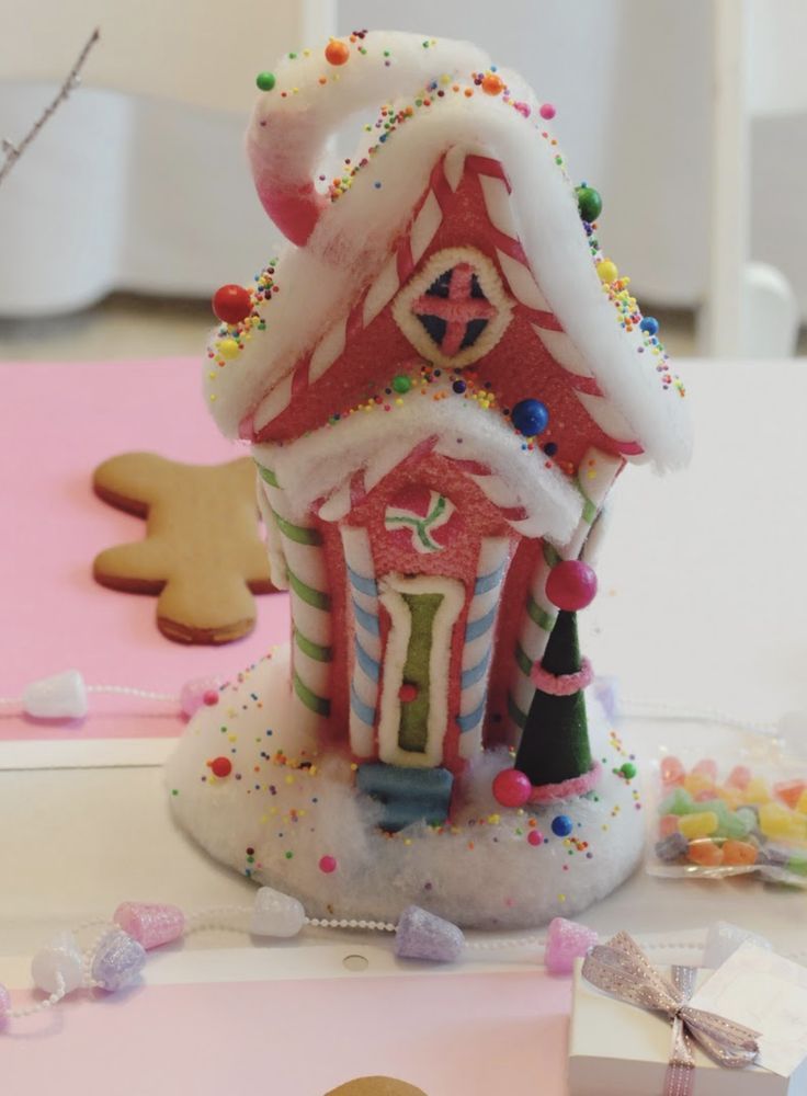 a gingerbread house decorated with icing and sprinkles on a table