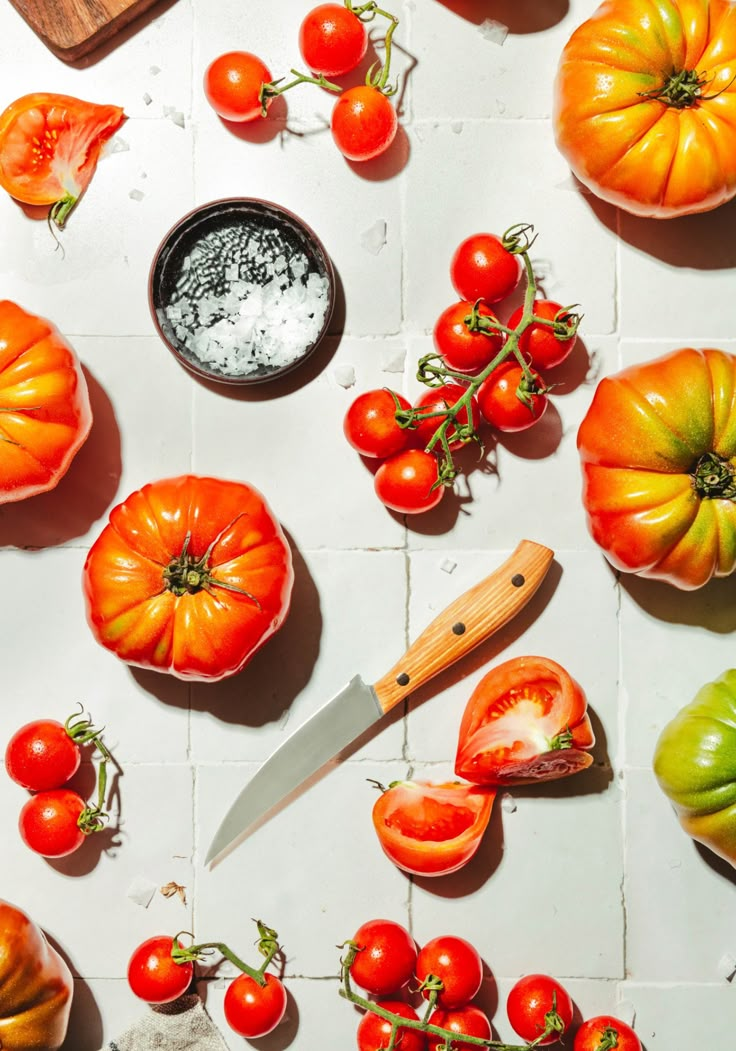 tomatoes and other vegetables are laid out on the table