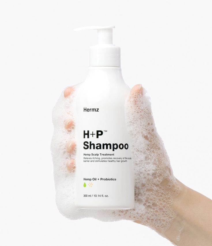 a hand holding a bottle of h + p shampoo in it's palm