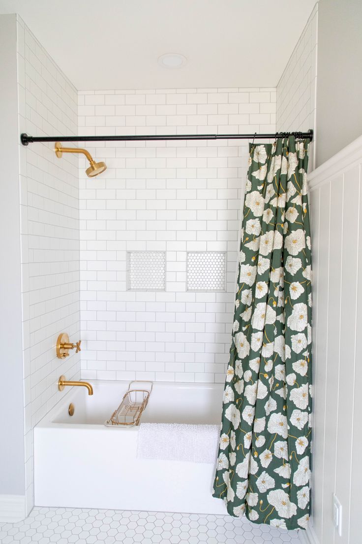 a bathroom with a tub, shower curtain and tiled floor