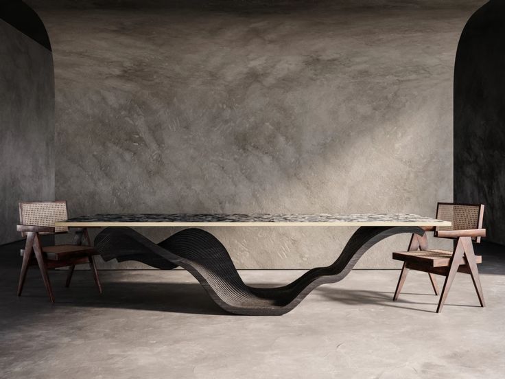 the table is made out of concrete and has two chairs around it, with an artistic design on top