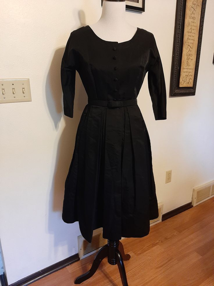 "Mid Century Womens Black Rayon Satin Taffeta Special Occasion Dress Size S Very Good Vintage Condition, No Rips Or Tears, Deodorant Residue Mainly Inside Under Arms. Will Need To Be Cleaned. Dress Has Been Hemmed Up And Could Be Let Down For A More Authentic 40s Length. No Labels Seen Fabric Appears To Be A Rayon Or Silk Satin Taffeta Beautiful Fabric, Not Sure Photos Give Justice Rounded/Boat Neckline 7 Covered Buttons In Front For Decor Closure Is Small Black Snaps And 1 Hook At Waist Raglan Black Retro Dress For Vintage Events, Black Dresses For Spring Vintage Events, Fitted Black Dress In 1950s Style, Classic Black Dress For Vintage Fashion, Black Vintage Dress For Vintage Fashion, Classic Black Dress For Vintage Events, Retro Black Vintage Dress For Evening, Black Vintage Dresses For Vintage Fashion, Fitted Black Dress With Box Pleat