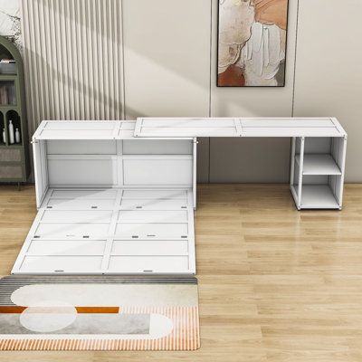 a white desk sitting on top of a hard wood floor next to a book shelf