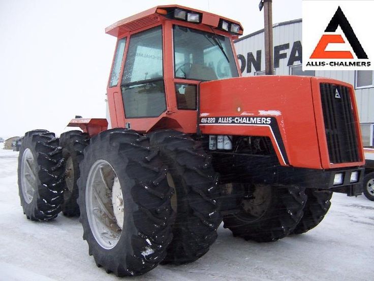 an orange tractor is parked in the snow