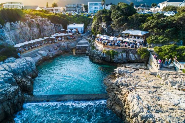 people are standing on the edge of an ocean cliff