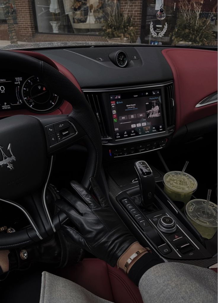 the interior of a car with red and black leather trims, steering wheel controls, and dashboard