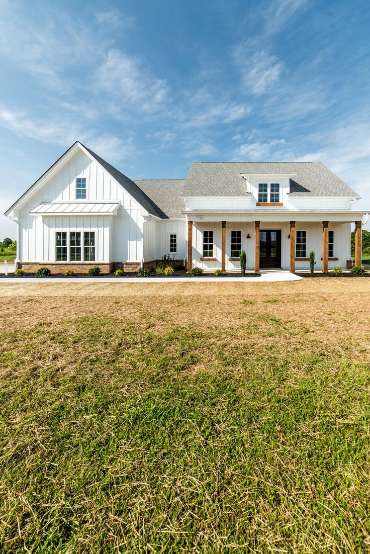 a large white house sitting on top of a lush green field