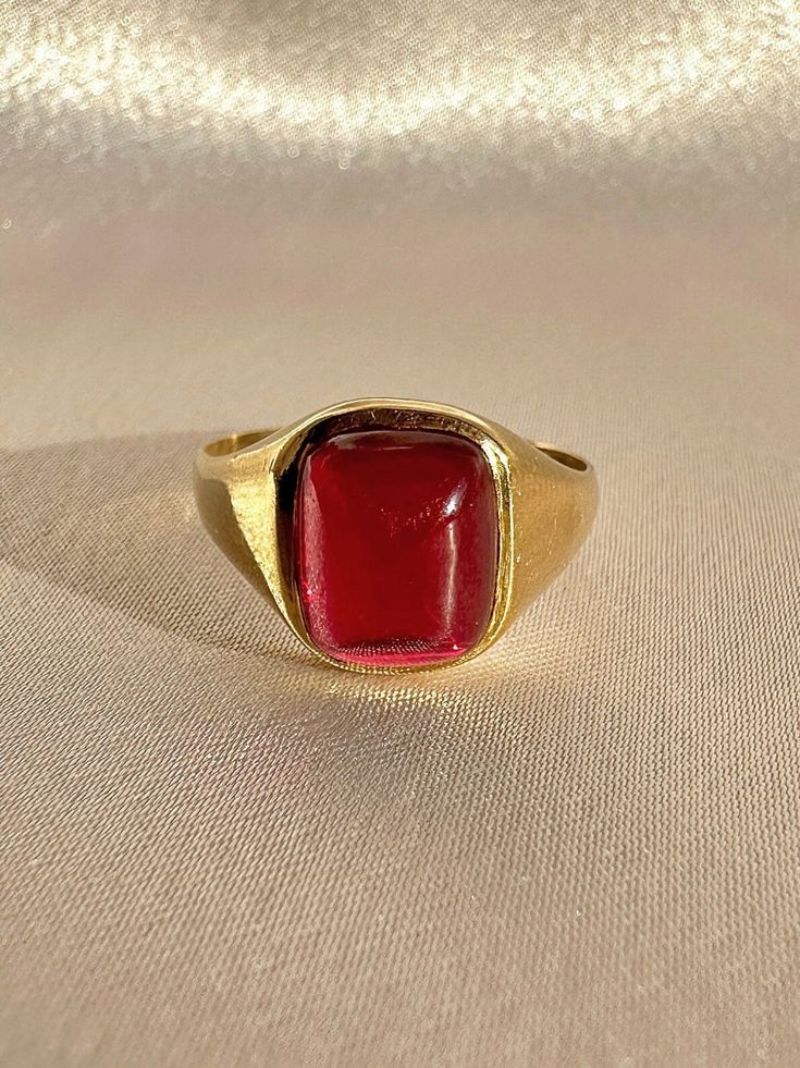 Antique 18k yellow gold ring from the United Kingdom. This signet ring features a vibrant synthetic ruby cabochon.  Great antique condition Size: 7.5 resizable** Weight: 3.5 grams Band: 11.1 mm (front), 1.7 mm (back) Synth Ruby: 8.3 mm x 10.0 mm  Hallmarks:18CT Please note, vintage and antique jewelry may come with imperfections commensurate of their age. To see more photos and videos of this piece, visit our Instagram: www.instagram.com/23carat PLEASE READ ALL POLICIES regarding shipping, returns, tax, etc Formal Ruby Signet Ring In Fine Jewelry Style, Fine Jewelry Ruby Signet Ring For Formal Occasions, Ruby Signet Ring Fine Jewelry For Formal Events, Ruby Signet Ring For Formal Occasions, Modern Red Cabochon Ring, Yellow Gold Ruby Signet Ring With Polished Finish, Classic Red Signet Ring For Formal Occasions, Ruby Signet Ring With Polished Finish, 14k Gold Cabochon Red Ring