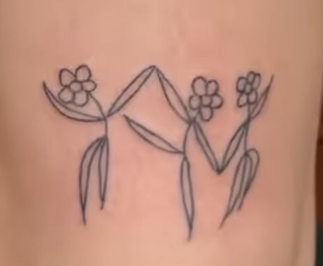 a woman's lower back tattoo with flowers on it