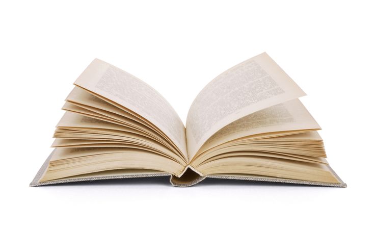 an open book sitting on top of a white table