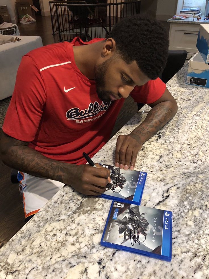 a man sitting at a table signing autographs