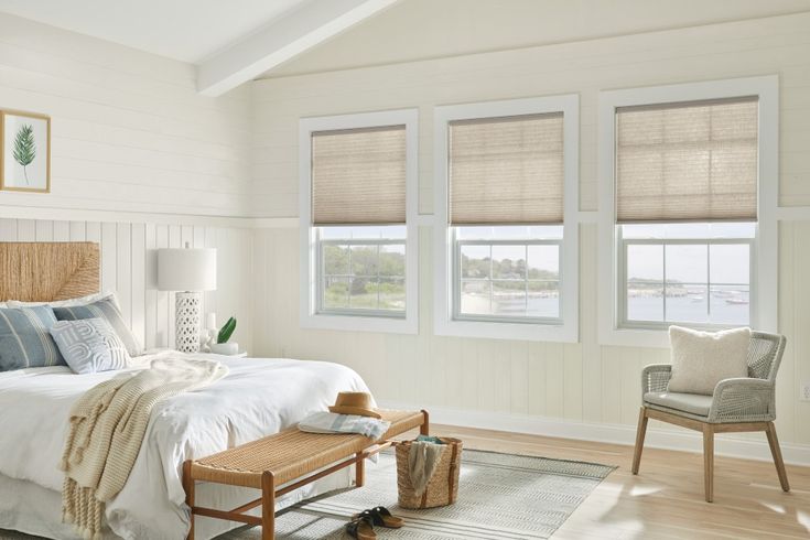 a bed sitting in a bedroom next to two windows with blinds on top of them