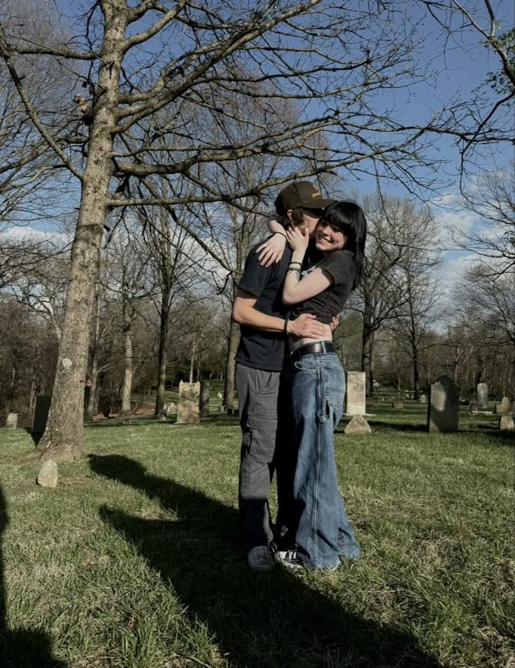 two people hugging each other in the grass