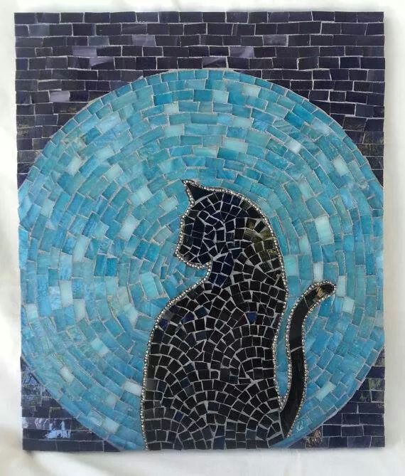 a black cat sitting on top of a blue and white mosaic tile wall art piece