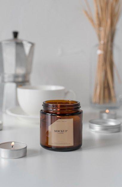 a candle sitting on top of a white table next to a cup and saucer