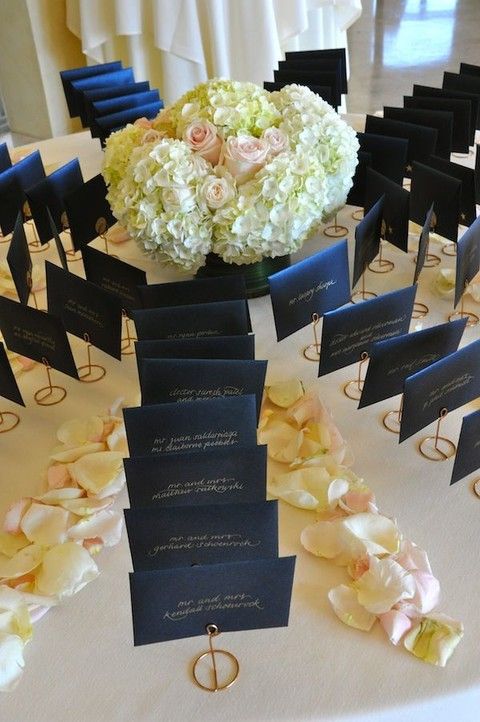 there is a table with place cards and flowers on it for guests to sit down