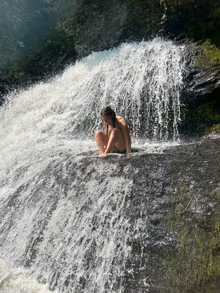 a man sitting on top of a waterfall