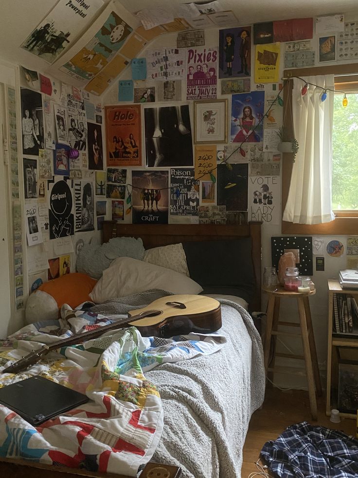 a bed room with a guitar on the wall and lots of papers all over it