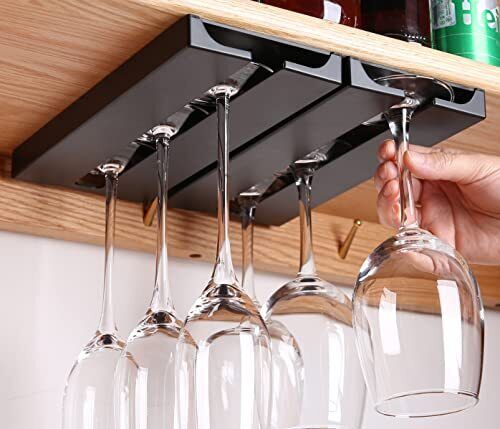 wine glasses are hanging from the shelf in front of some bottles and glass goblets