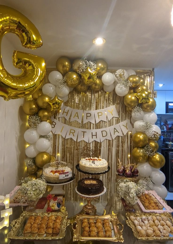 a birthday party with balloons, cake and desserts