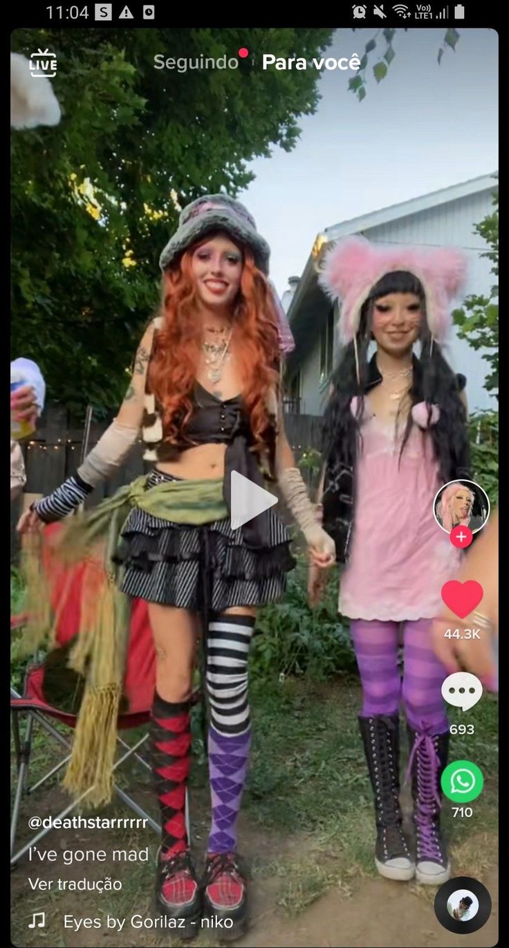 two women dressed in costumes holding hands