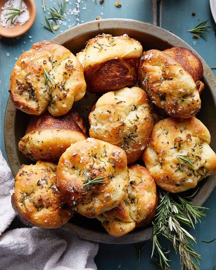 a bowl filled with bread and herbs on top of a table