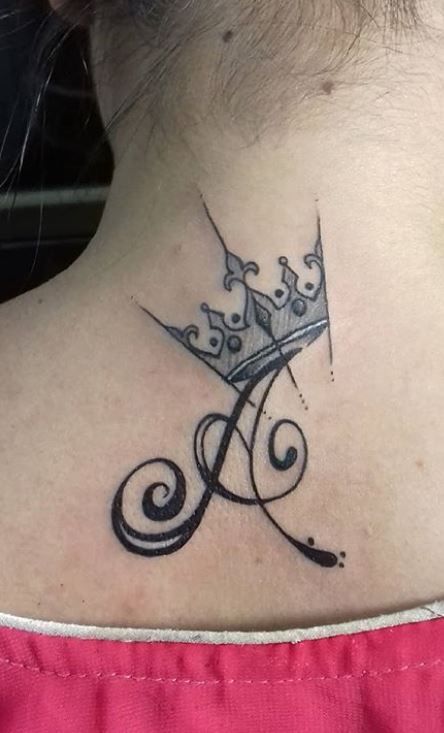 a woman's neck with a crown tattoo on her left side ribcage