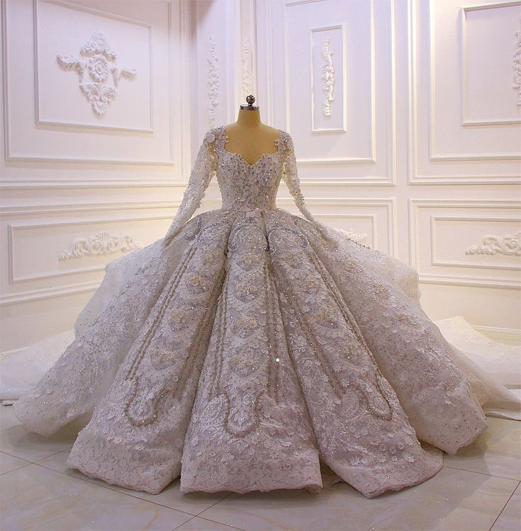 a wedding dress on display in a white room