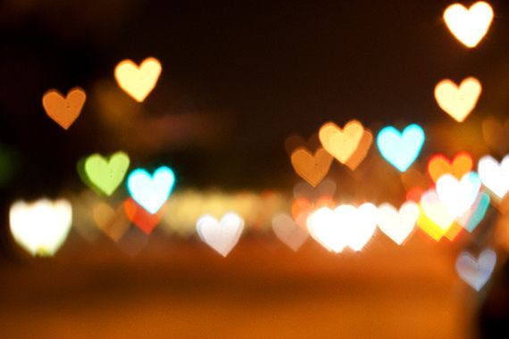 blurry image of many hearts in the night sky with buildings and street lights behind them