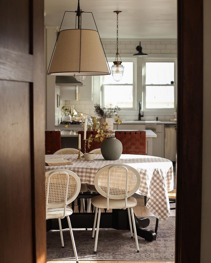 a dining room table with chairs and a lamp