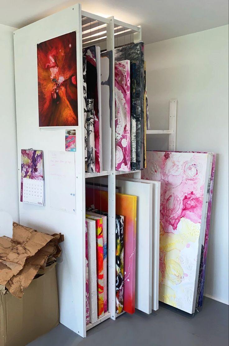 an open bookcase filled with lots of books next to a wall mounted art piece