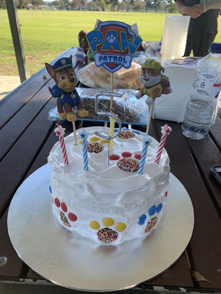 a birthday cake sitting on top of a table with candles in the shape of animals